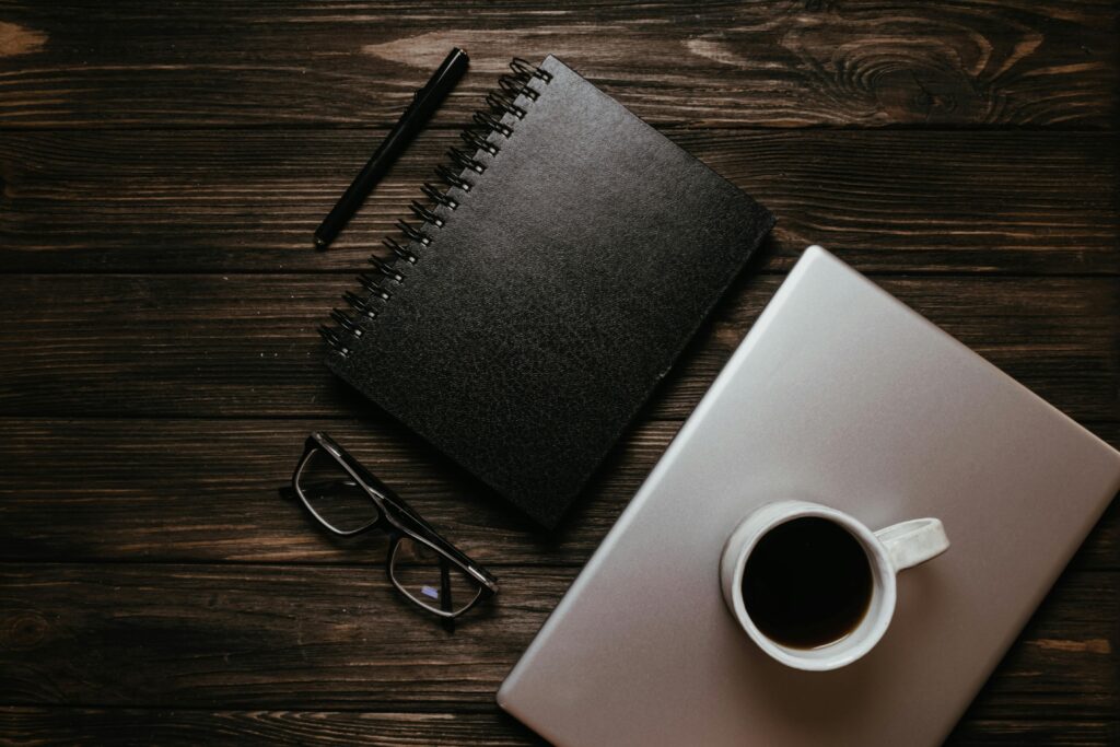 Journal and a cup of coffee flat-lay on bench Journal and a cup of coffee flat-lay on bench