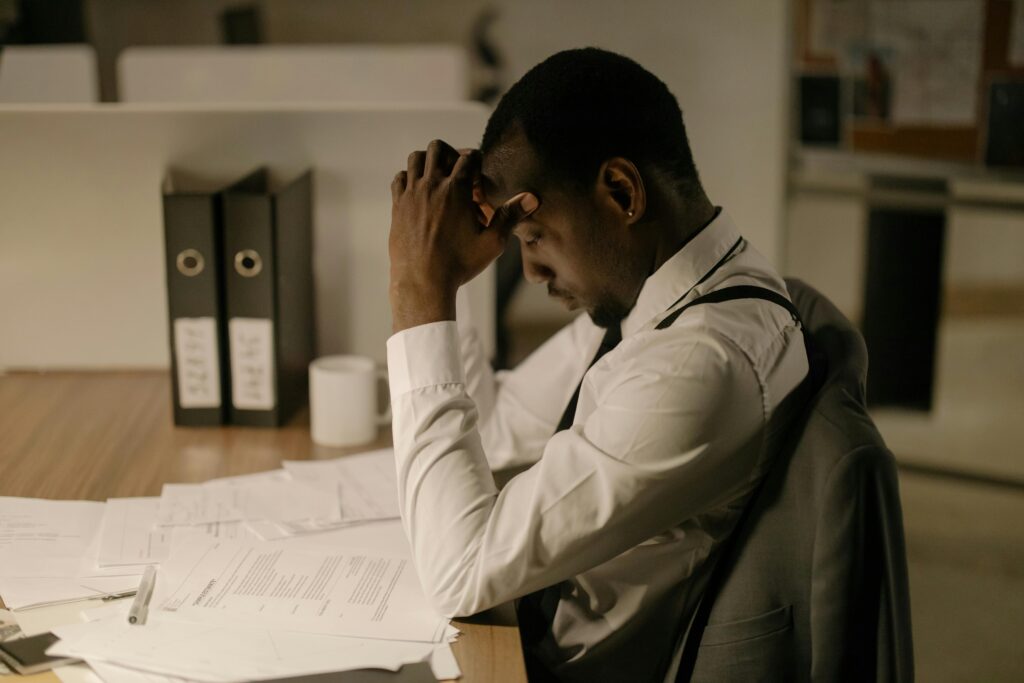 Understanding Why We Procrastinate Man sitting at desk procrastinating with unfinished tasks and distractions