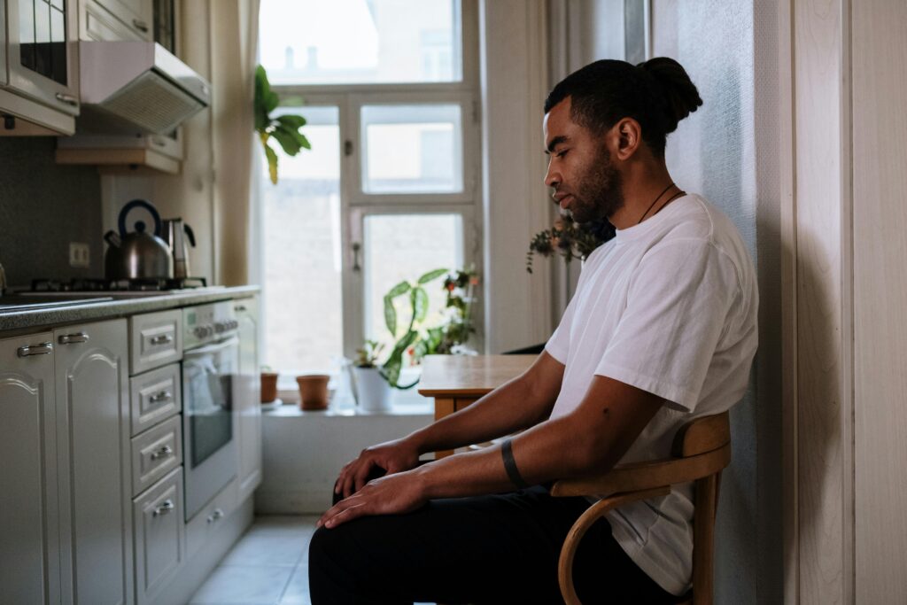 How To Stop Overthinking and Start Living A person reflecting calmly near a window, learning self-awareness to stop overthinking.