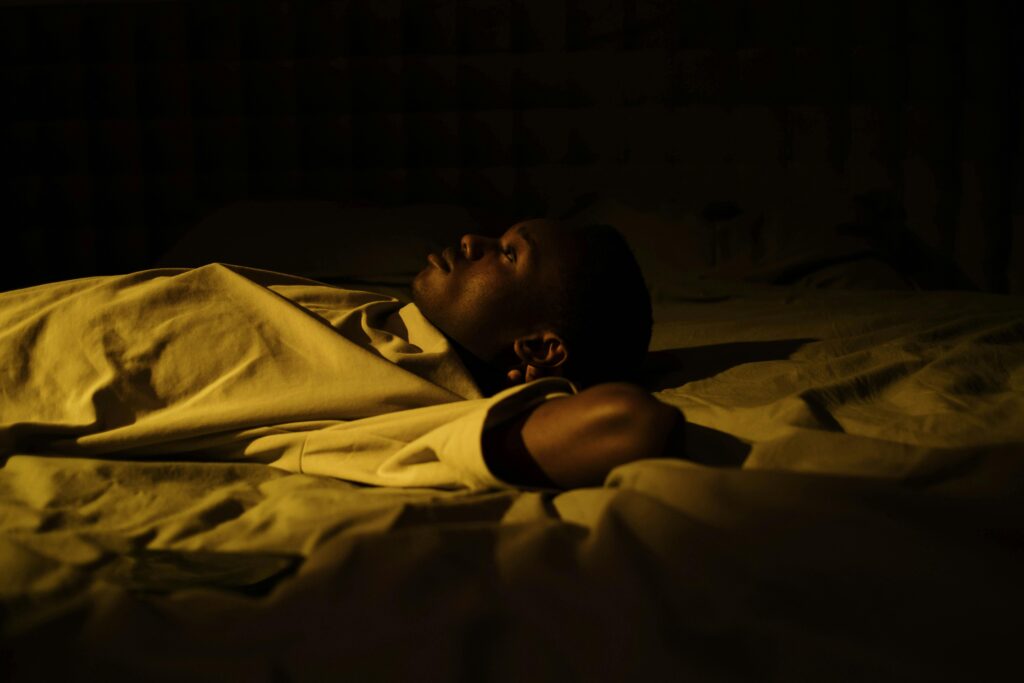 Man lying awake at night unable to sleep due to overthinking and racing thoughts