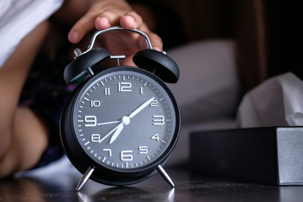 Early morning alarm clock representing the discipline of doing hard tasks first thing every day