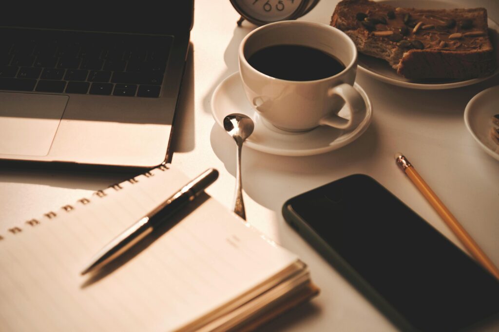 Minimal morning routine setup with notebook, pen, and coffee for mental clarity.