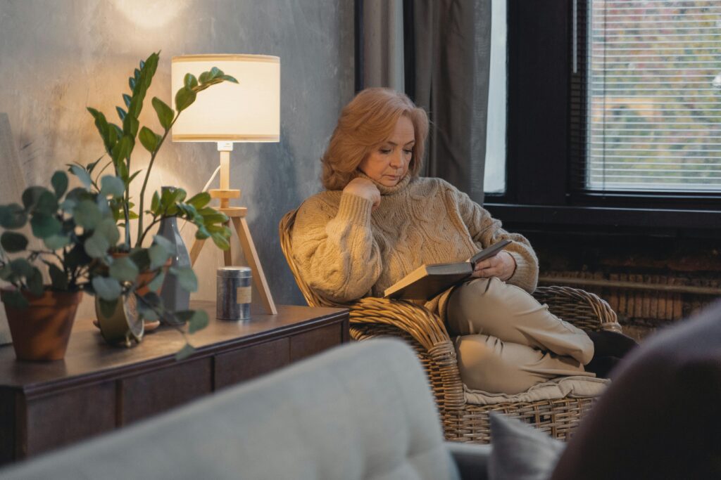 Coffee and book on cozy armchair representing the burnout recovery step of reconnecting with simple enjoyable activities